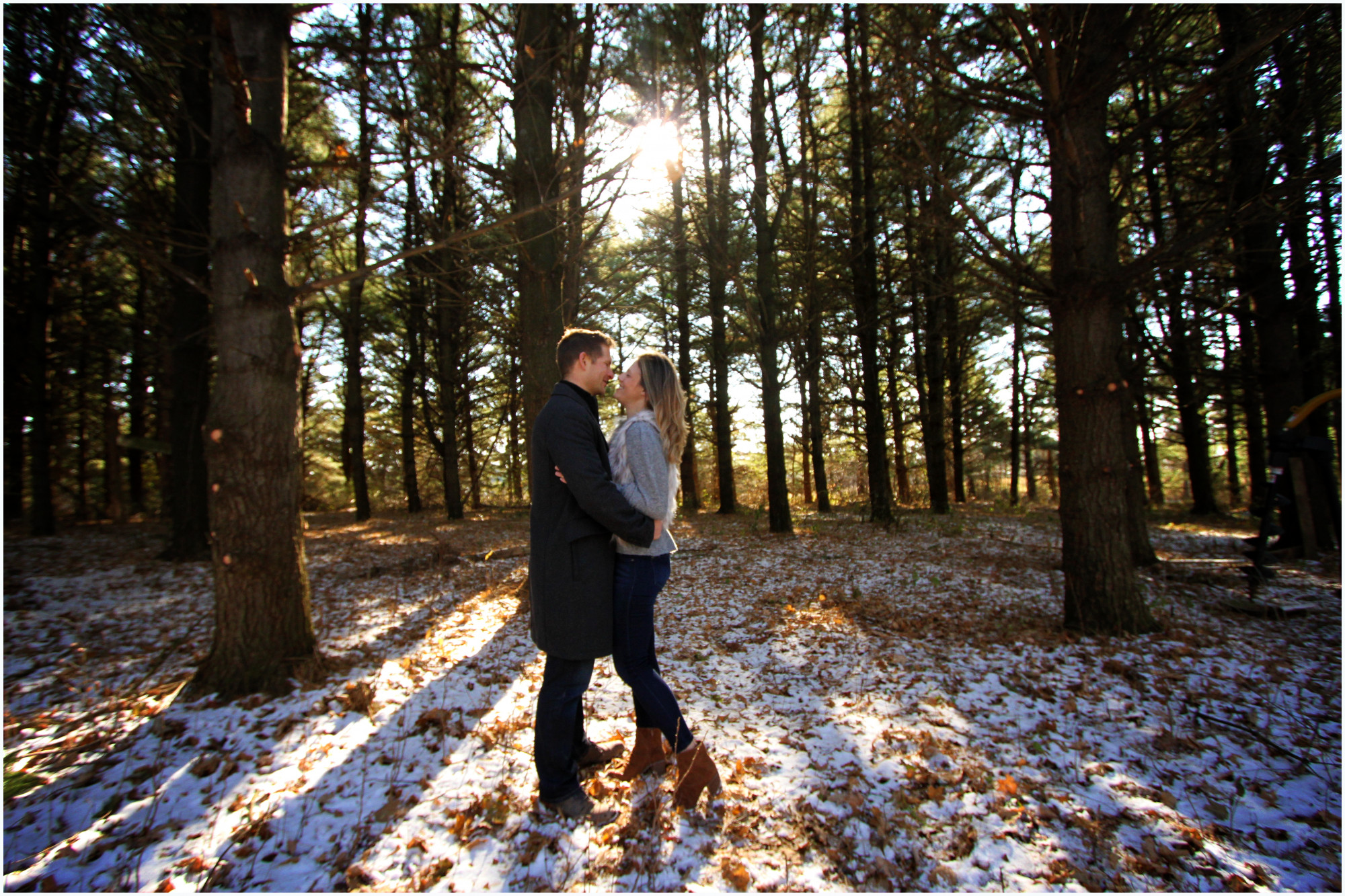 husband kissing wife in woods