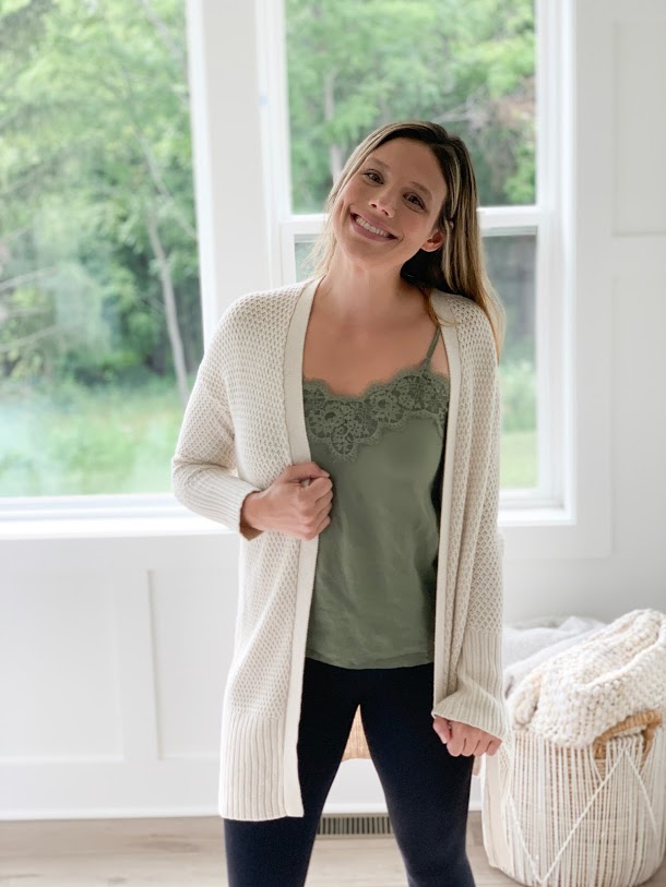 woman with lace cami and cream cardigan sweater smiling