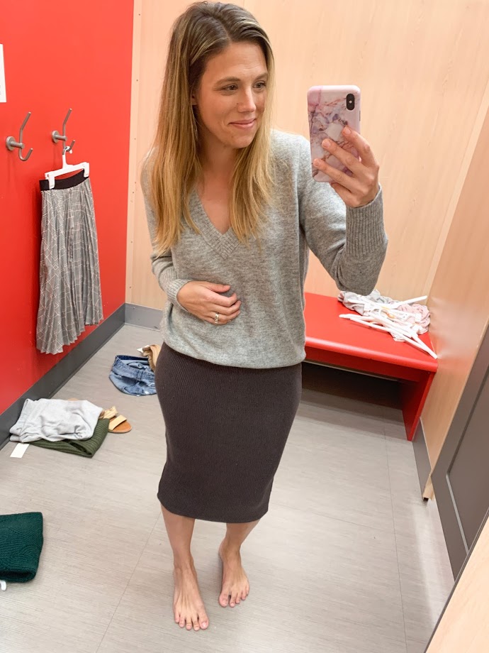 girl in dressing room with grey sweater and midi skirt