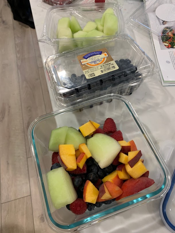 meal preparation with glass containers and fruit salad